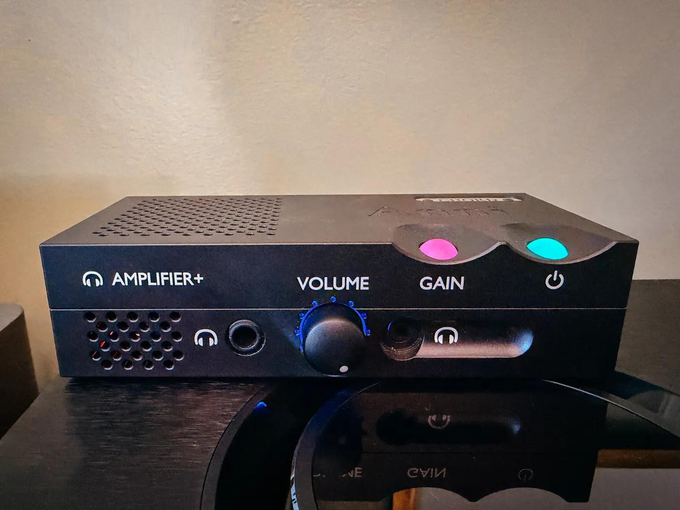 Chord Anni desktop amplifier photographed head on, its gain orb glowing red for high gain and its power orb glowing cyan